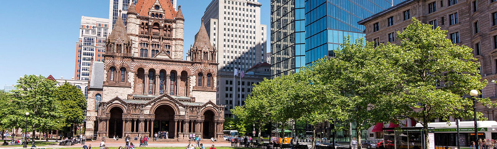 A photo of people sitting on grass at Boston’s Copley Square