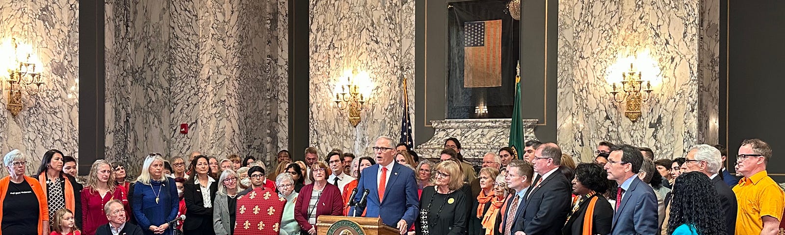 Group of people standing by a podium with an American flag in background