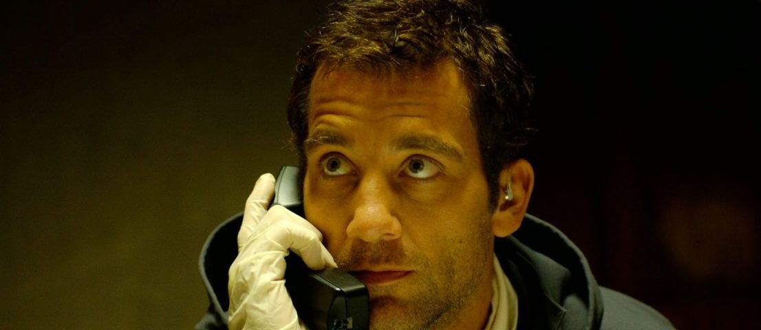 Clive Owen holds a phone to his ear in Inside Man