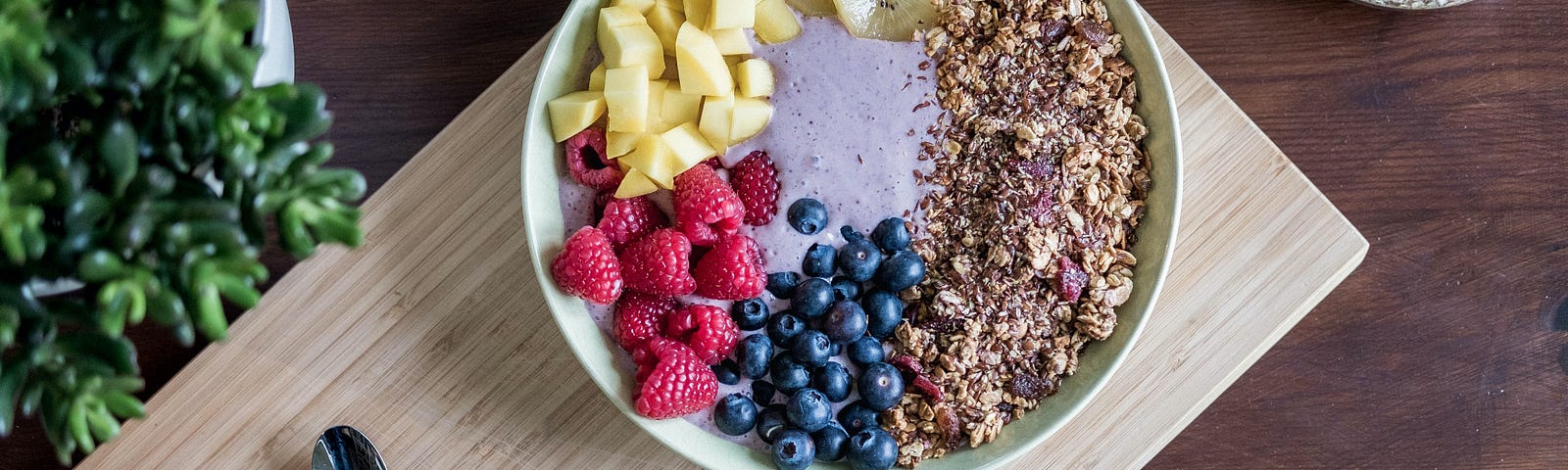 Breakfast smoothie bowl with fruit on a cutting board