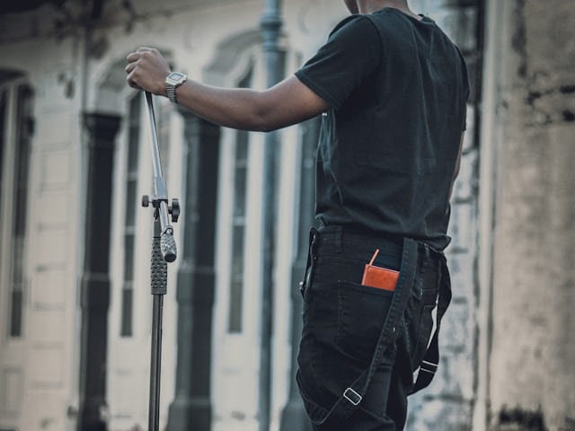 man in blue t-shirt and black pants holding black metal rod