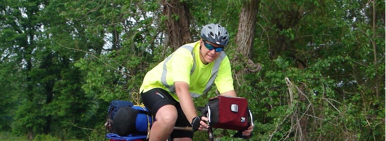 Jeff with his touring bike loaded down with panniers on front and back and sleeping gear on the back rack.