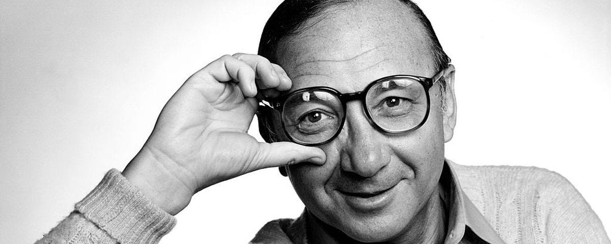 A photo of a smiling Neil Simon in glasses