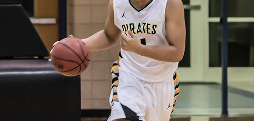 Photo of my son, Blake Scott, playing college basketball. He has a look of determination in his eyes.