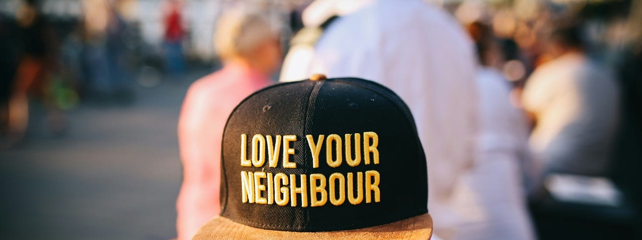 Man wearing ballcap that says “Love your neighbor”