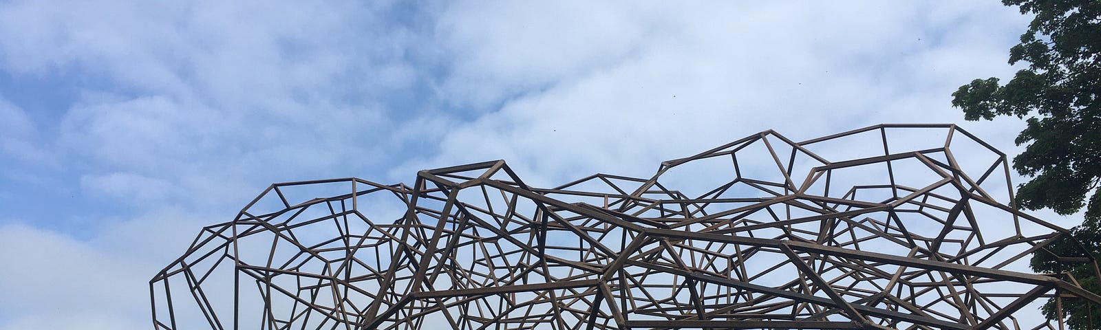 Sculpture made of black steel bars connecting to each other at constelation points, silhouetted against the sky