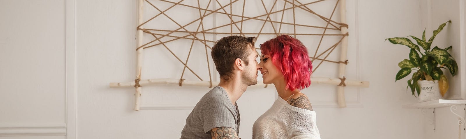 A couple flirts playfully together on a bed.