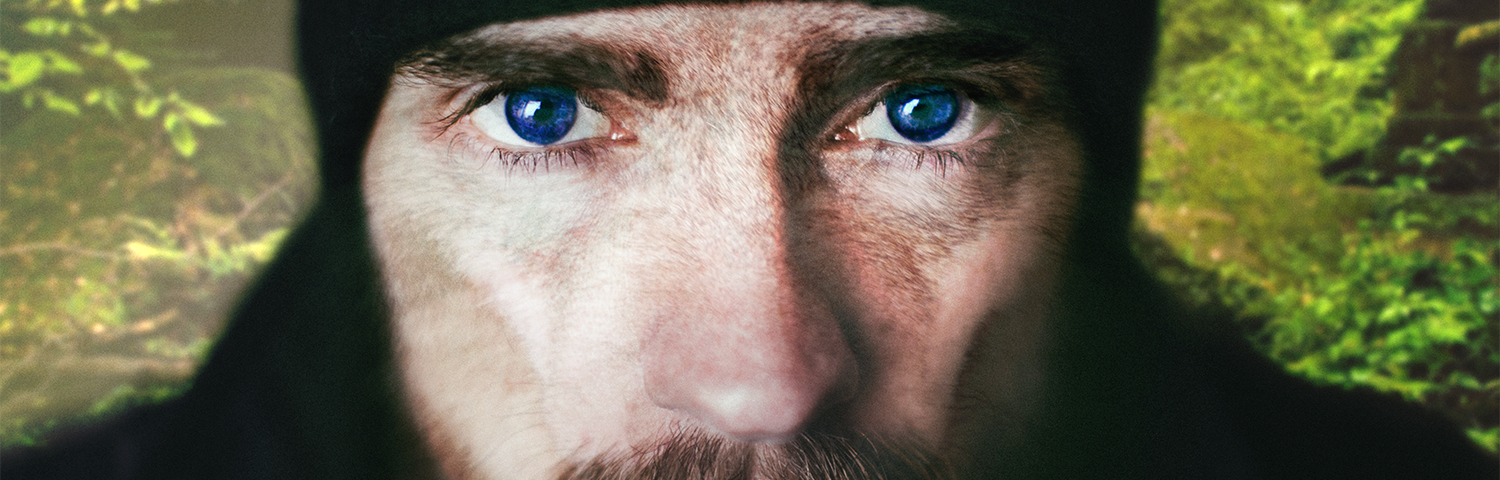 A bearded man with features of a werewolf and a forest background