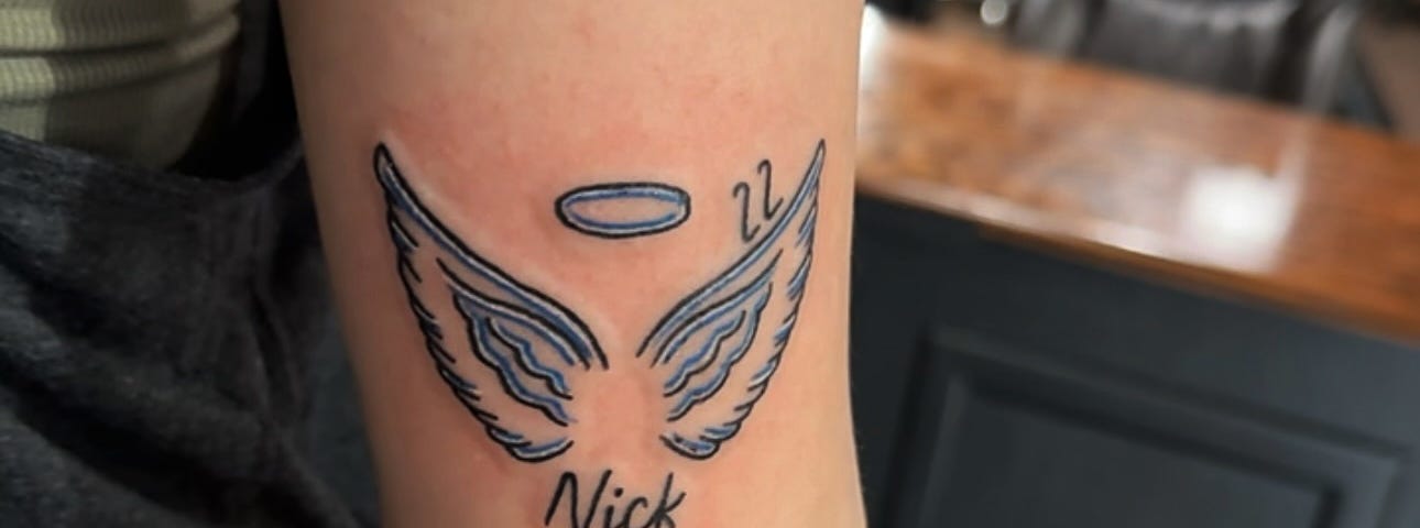 memorial tattoo of authors boyfriends name and angel wings