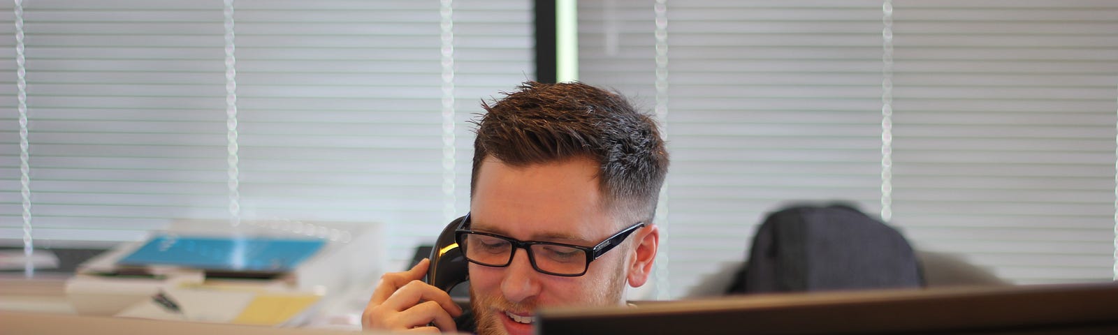 A consultant working at his desk, on a phone call.