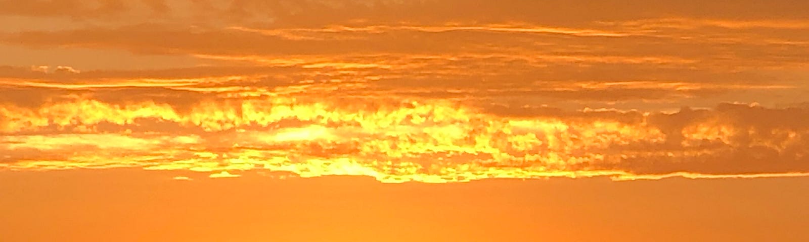 Orange sunset — the clouds look like a wave washing onto the shore