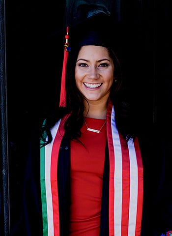 Aseret Bertram is pictured in her graduation cap and gown against a dark background