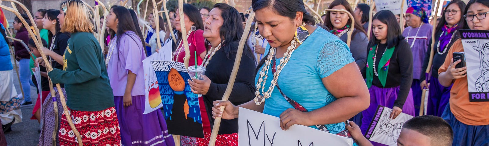 Native American women and children marching in a protest.