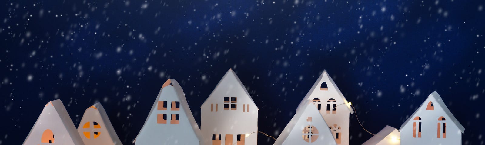 Snowfall in winter village made of paper. Paper winter night landscape. Christmas greeting card.