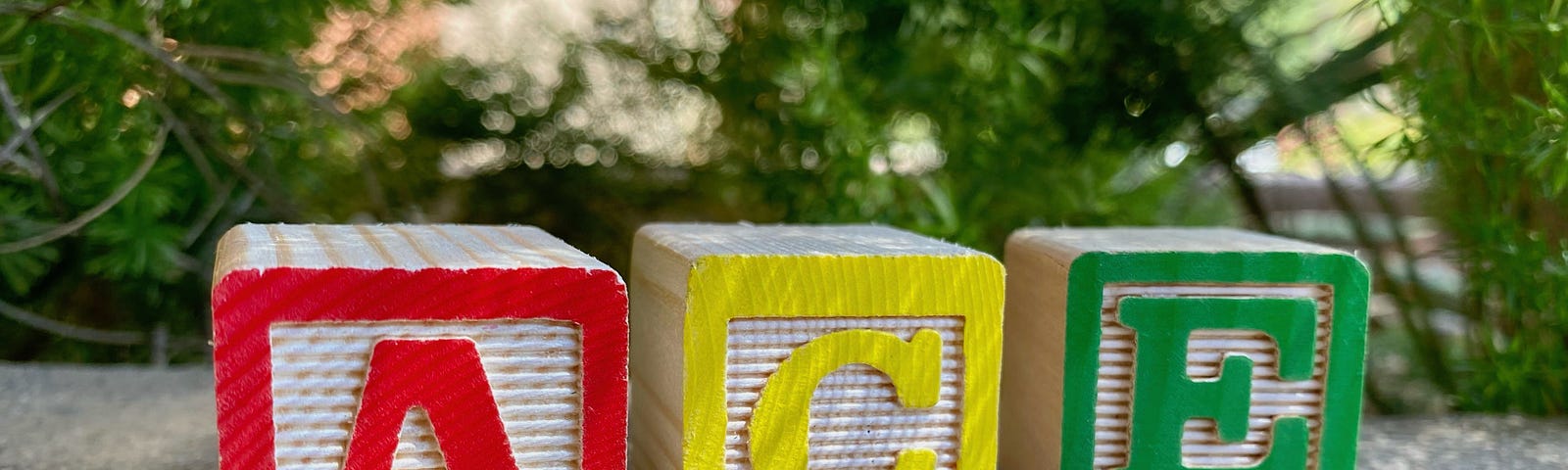 Three colorful wood blocks spelling out “ace.”