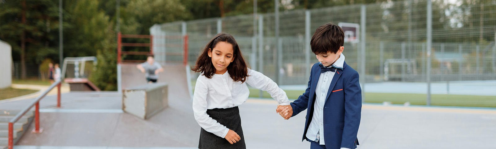 Girl Holding the Hand of a Boy While Riding a Skateboard