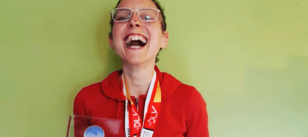 photo of author smiling with medals and prize