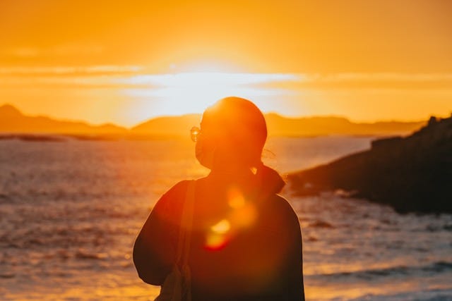 Woman looking at setting sun