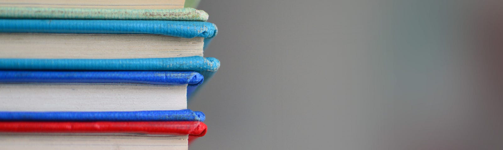Stock image of the side of a stack of brightly coloured books