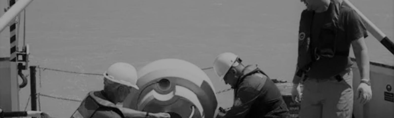 Marine engineers and technicians deploying an ocean data buoy