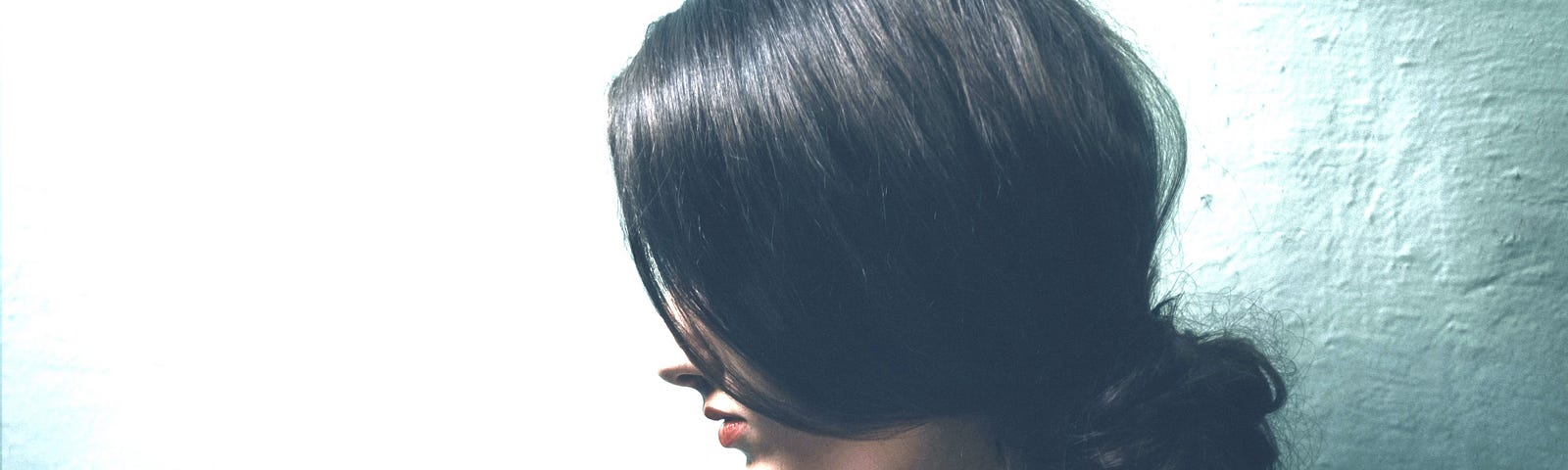 A photo profile of a Asian woman with a white illuminated background.