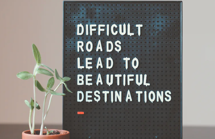 Quote on a board that says difficutl roads lead to beautiful destinations