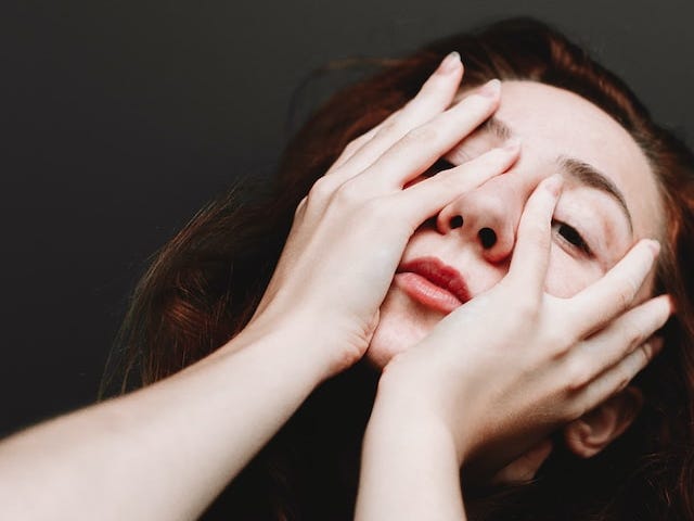 Woman covering her face and looking through her fingers