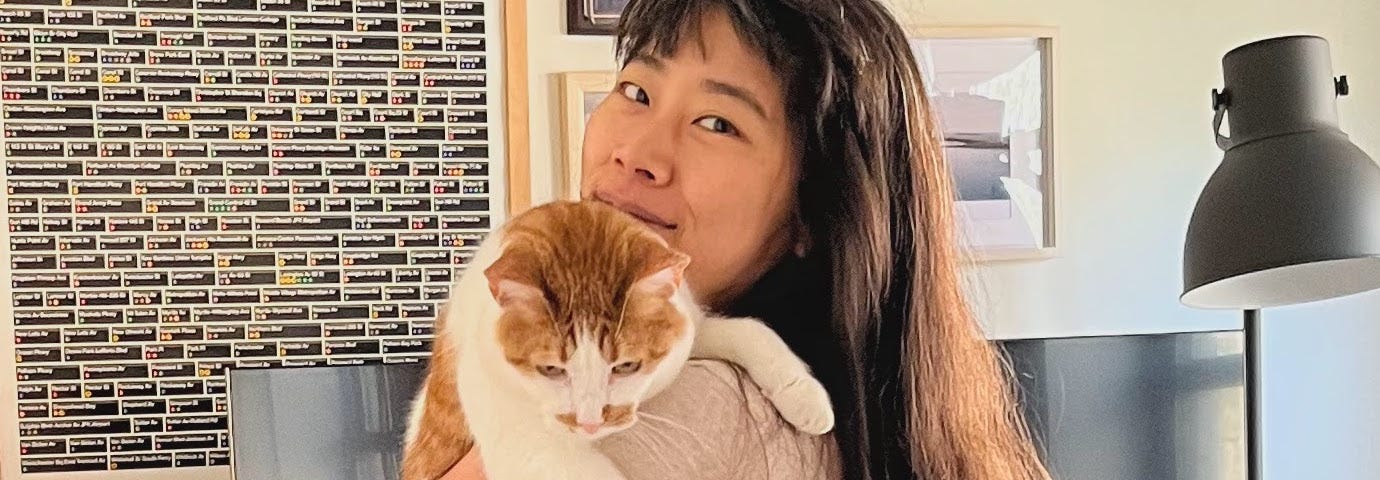 Photograph of Yoko Sakao Ohama holding an orange-and-white cat