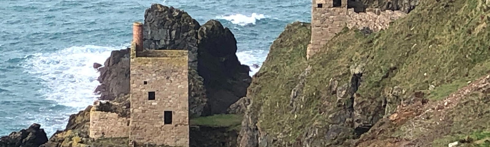 A crumbling tower stands on the Cornish coastline