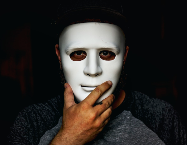 Man holding a mask in front of his face