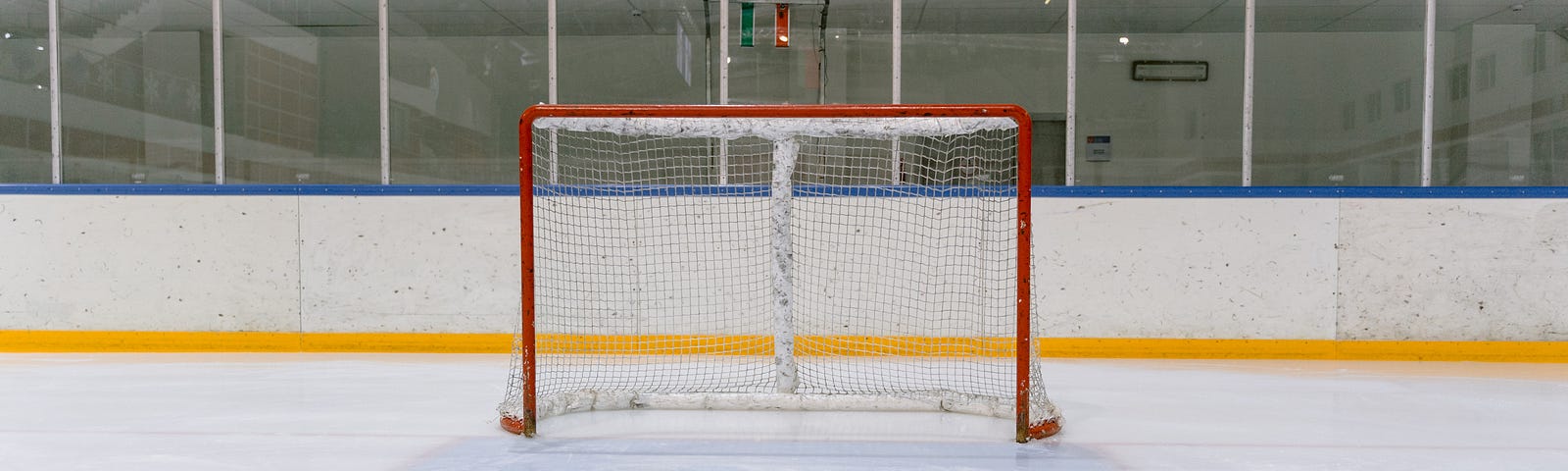 A hockey net on a sheet of ice.
