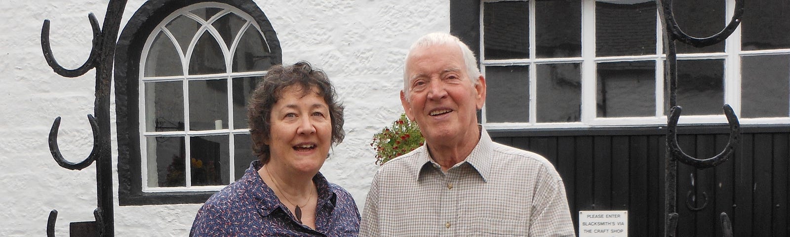 The photo shows Elizabeth Pepper and her late husband Alan standing together in front of a building.