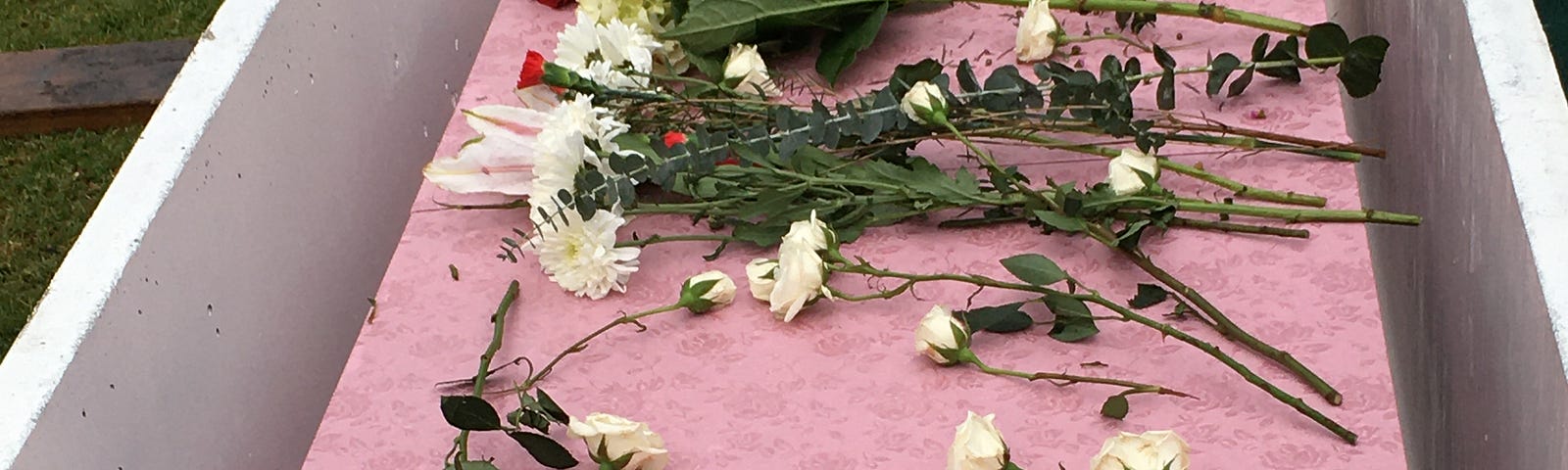 Pink casket for Eileen. Myself and another woman named Claudia placed white and an occasional red rose upon it.