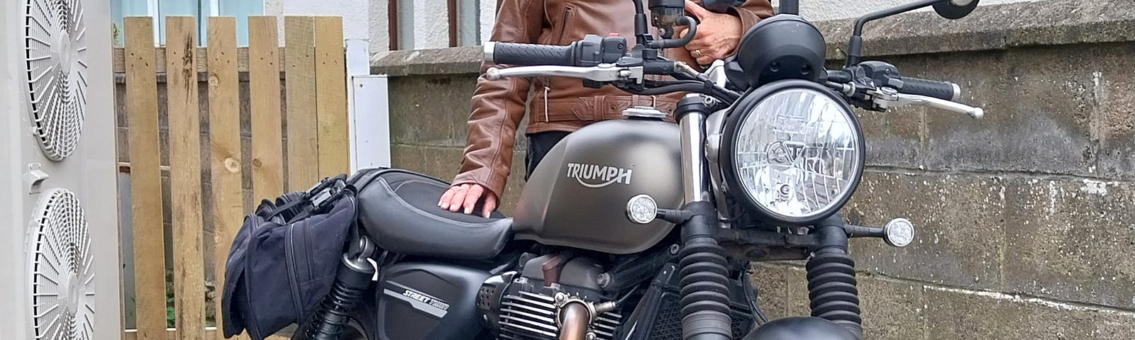 Female pillion standing next to Triumph Street Twin 900 motorbike after first ride