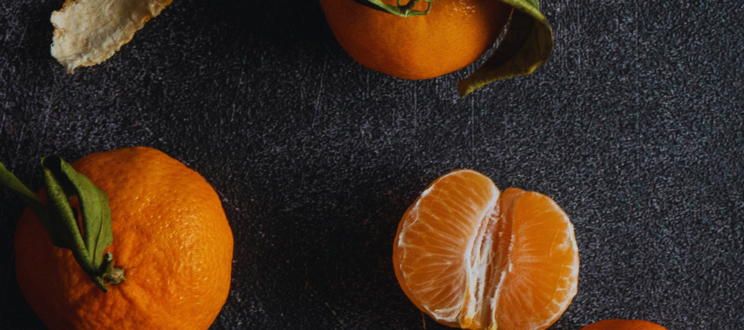 A few clementines scattered about. One is peeled and halved.