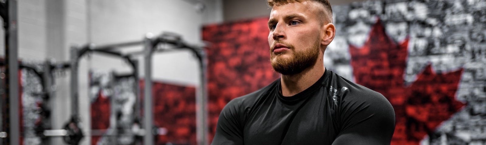 Young muscular man in a full-sleeved black shirt crossing his arms