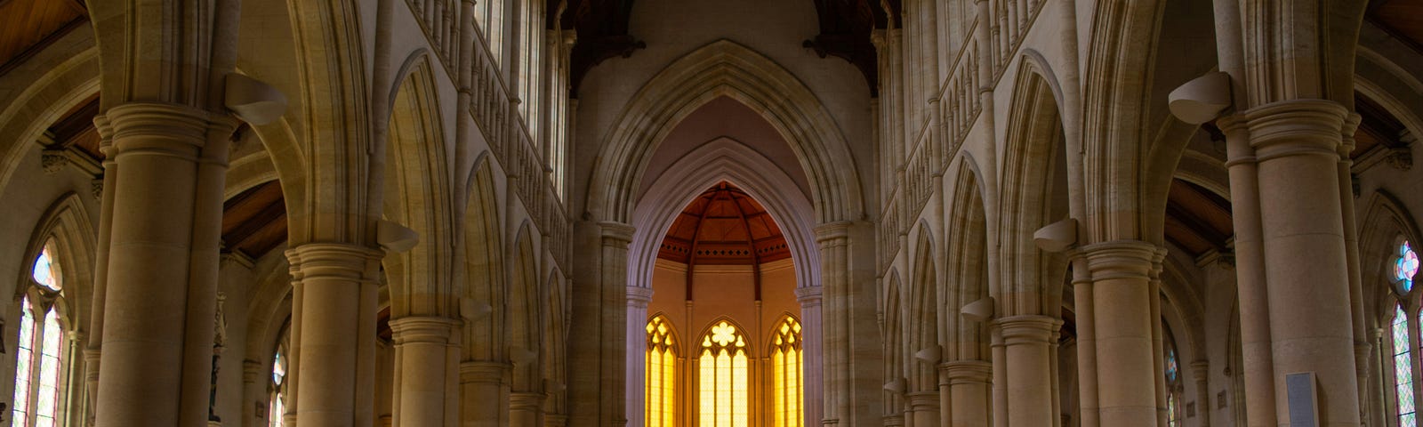 View from the back of a church with lighted windows.
