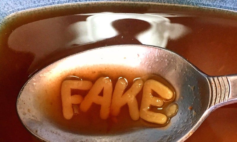 Soup Spoon with Spagetti showing word “Fake”.