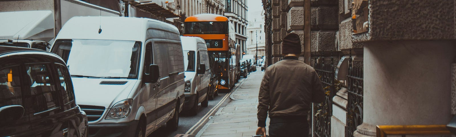 A man rolling a suitcase down a busy sidewalk