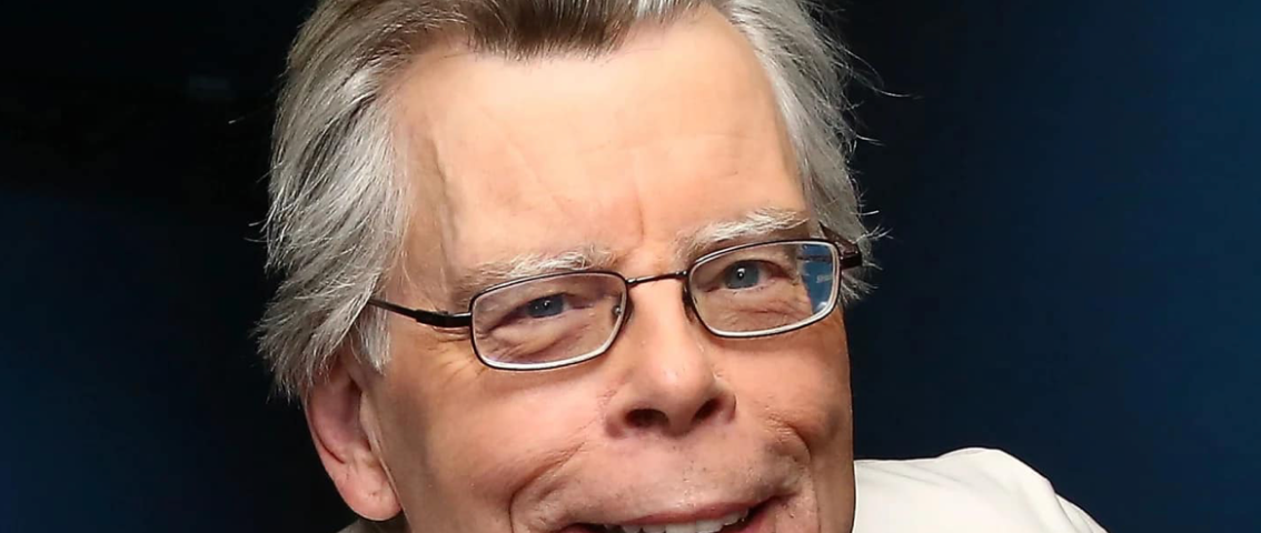 Photo of author Stephen King. He has silver hair, glasses and a white jacket.