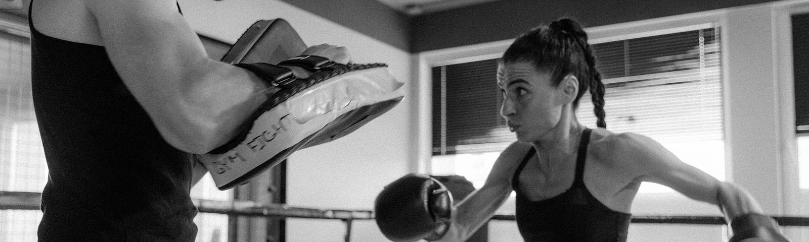 Grayscale Photo of a Woman Boxing