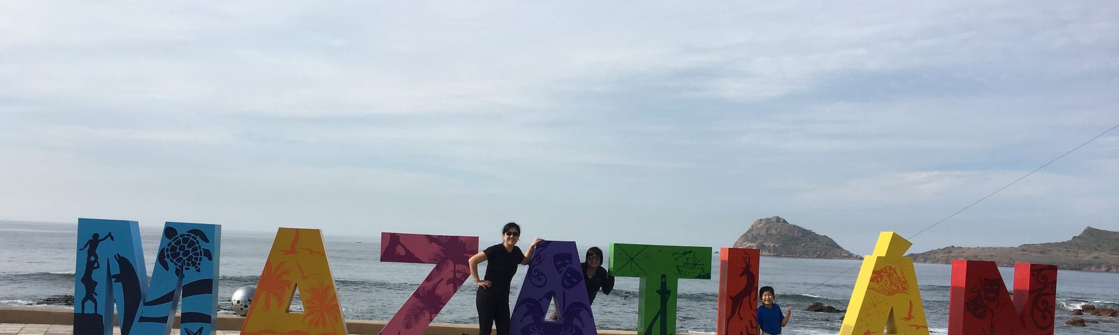 Three people pose next to the large letters (each about 5' tall) spelling out Mazatlan