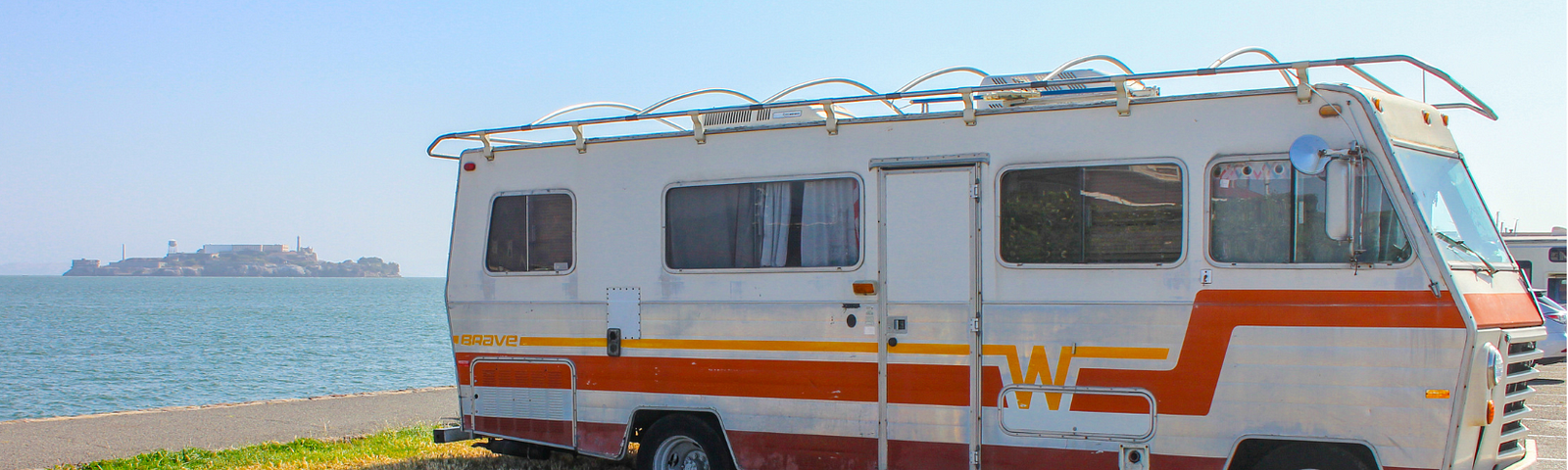 Old RV in a parking lot; alt-text for “I Had the Best Night’s Sleep in a Cracker Barrel Parking Lot”