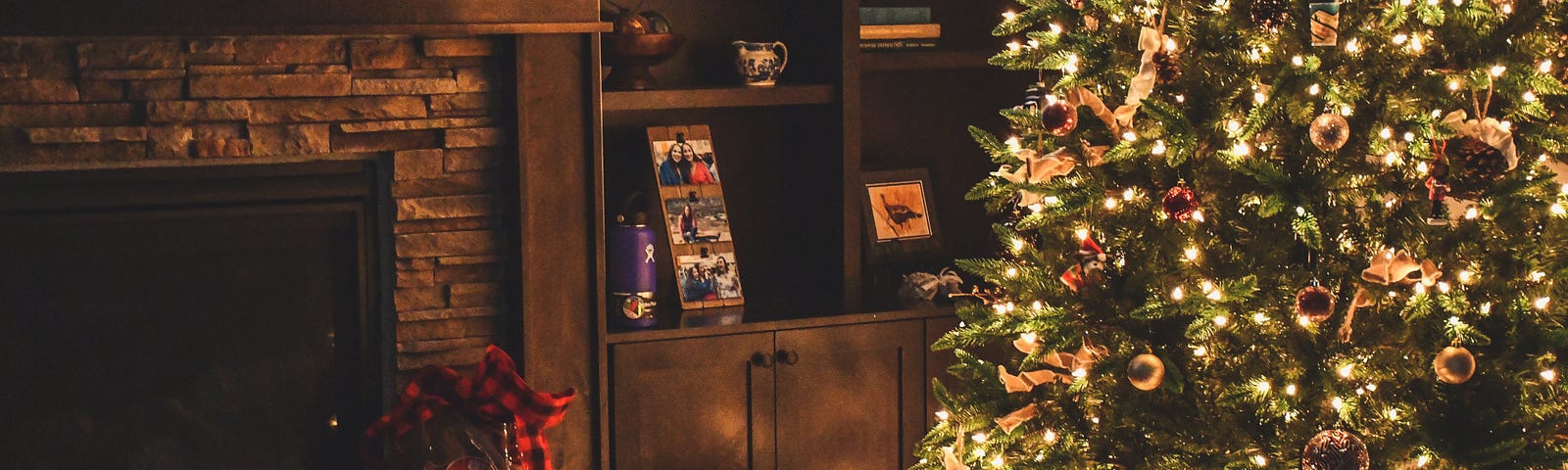A living room with a christmas tree and gifts near the fireplace.