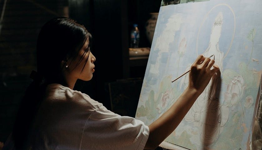 An artist painting on a large canvas.