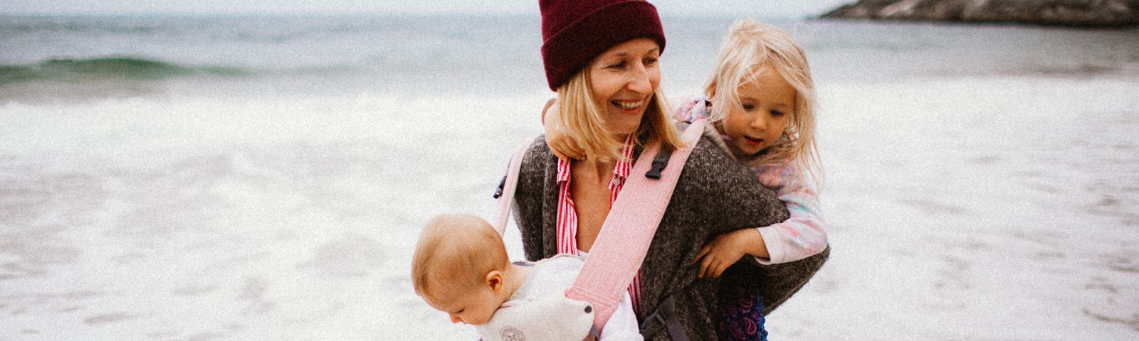 Happy smiling family walking on the beach with children