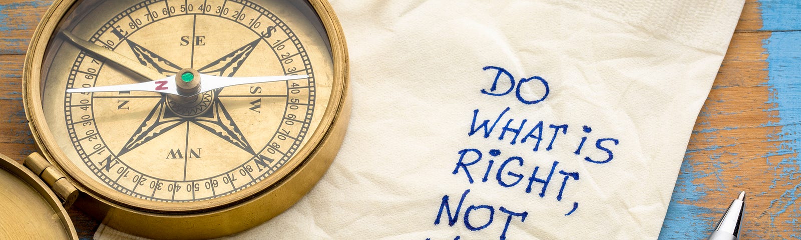 Desktop with a compass, napkin and pen. Written on the napkin are the words “DO WHAT IS RIGHT, NOT WHAT IT IS EASY.”