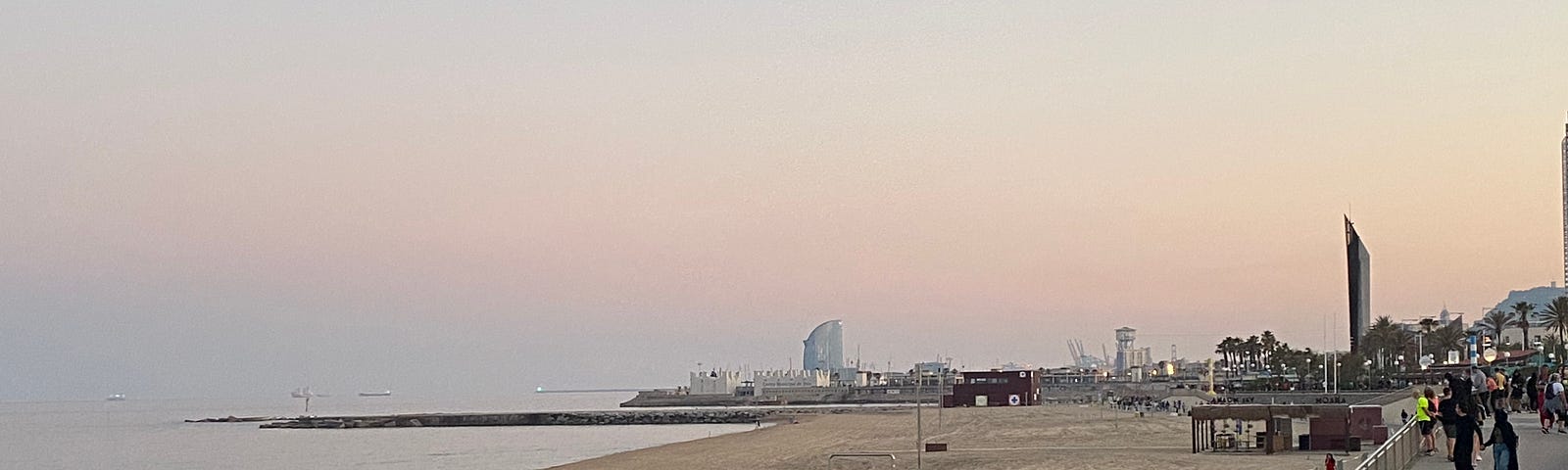 A Barcelona beachside promenade at dusk.