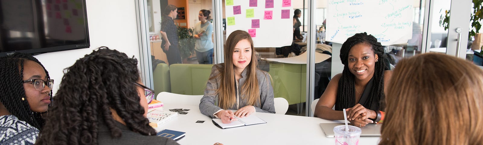 Product Managers sentadas em volta de uma mesa em reunião