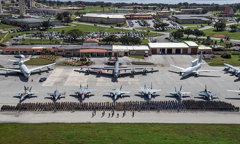 Airplanes and jets lined up behind many people